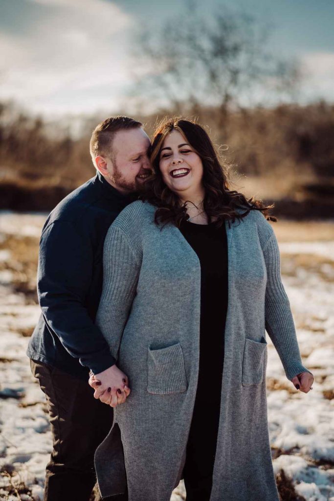A man and woman snuggle closely during a winter Haley Farm engagement session.