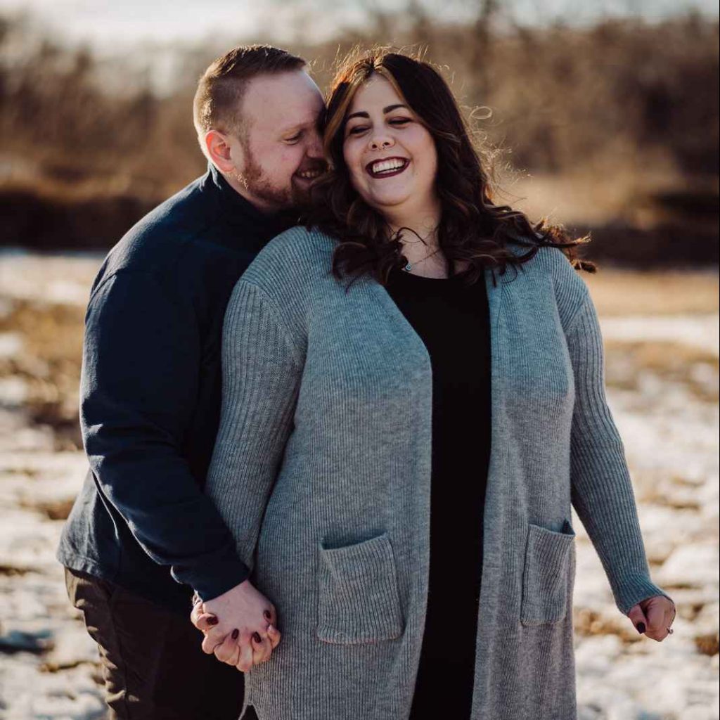 A man and woman snuggle closely during a winter Haley Farm engagement session.