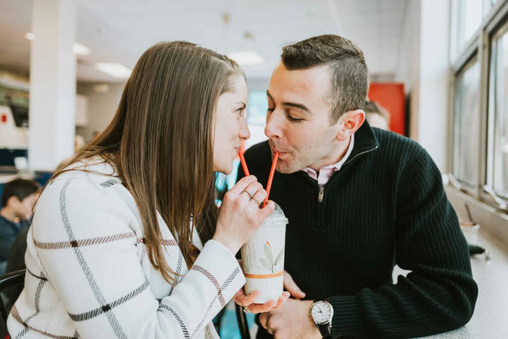 A couple enjoys a milkshake together at the UConn Dairy Bar during their engagement session.