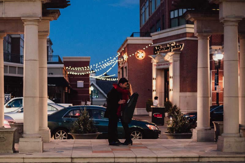 A couple embraces in Blue Back Square after a surprise proposal.