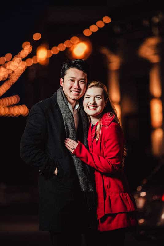 A man and woman smile together during a nighttime West Hartford engagement session.