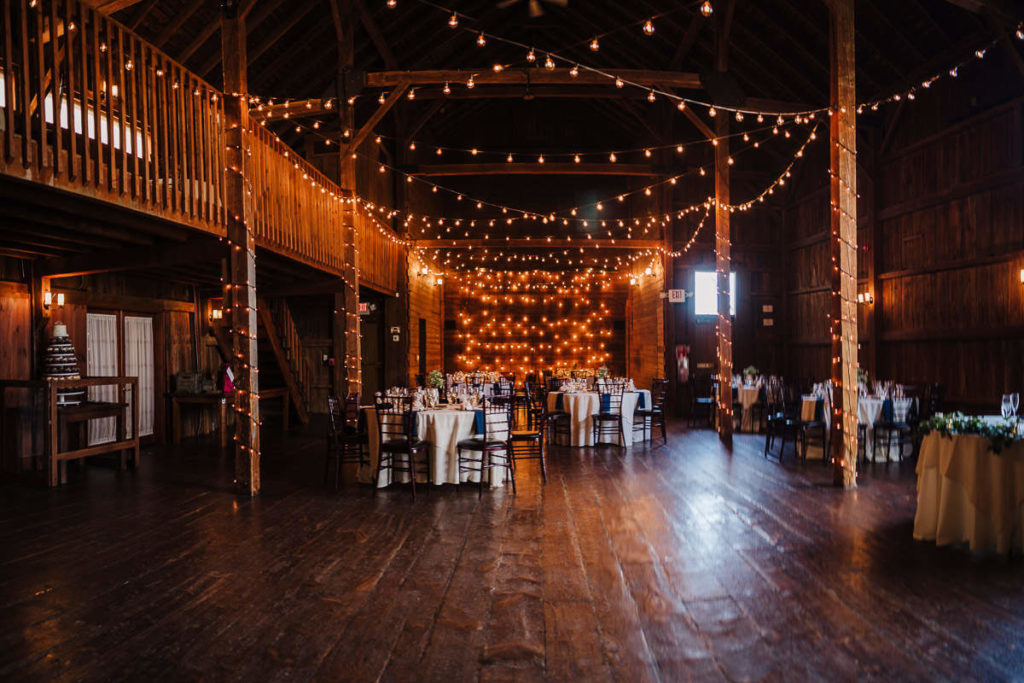 The Big Barn, adorned with lights and table settings for a Barns at Wesleyan Hills wedding.