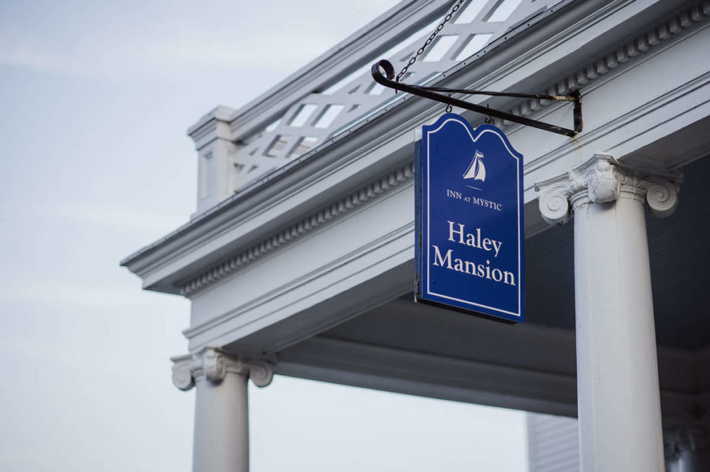 A blue sign on the side of Inn at Mystic's Haley Mansion, a Connecticut wedding venue in Mystic, CT.