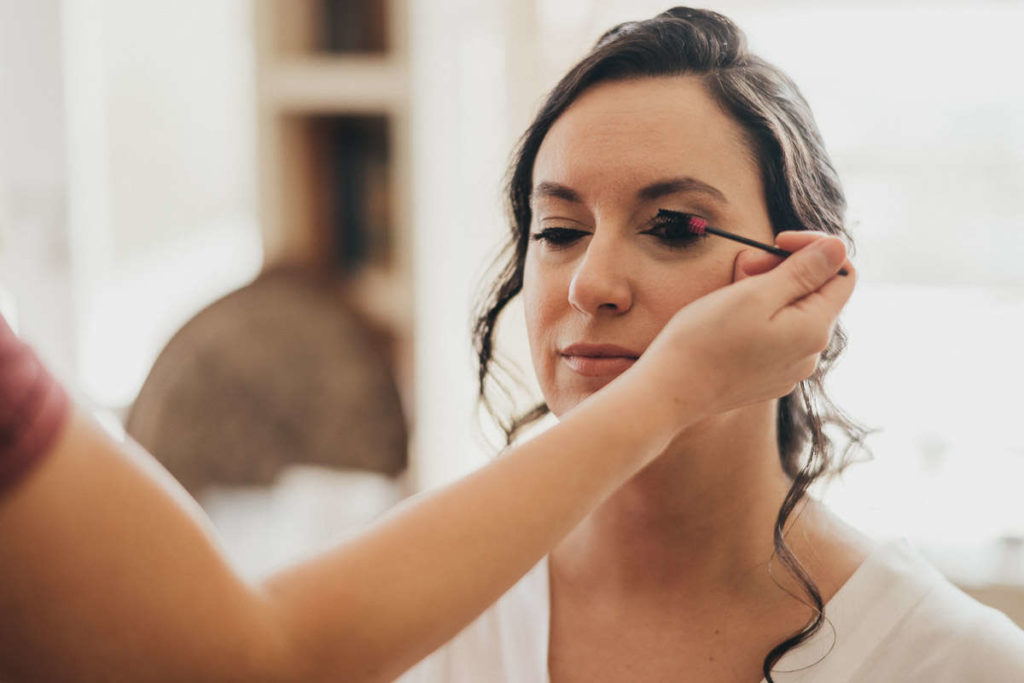 Inside Haley Mansion, a bride has her makeup touched up before her Inn at Mystic wedding.
