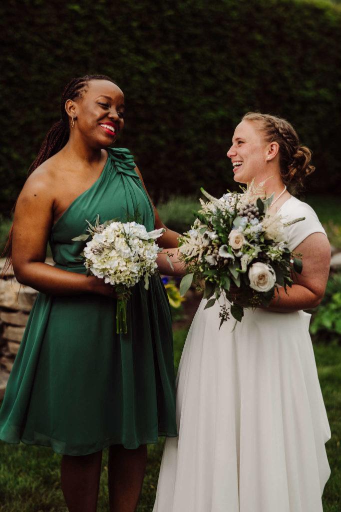 A bride and her bridesmaid pose during her Salem Herbfarm wedding.