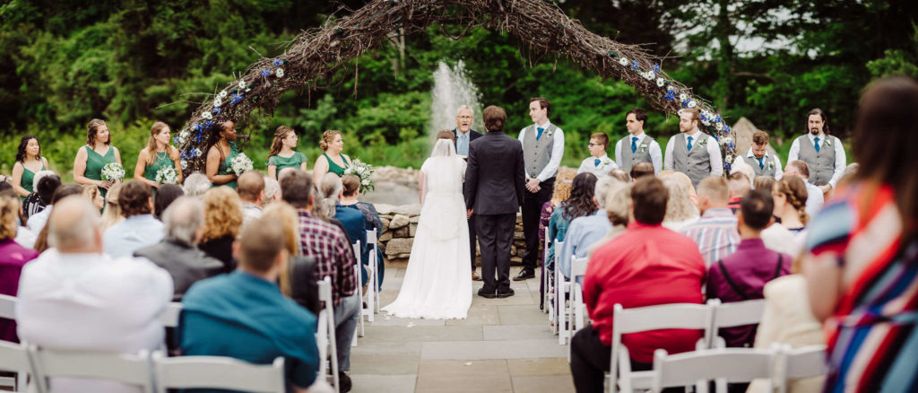 A rainy spring Salem Herbfarm wedding ceremony in front of the fountain.