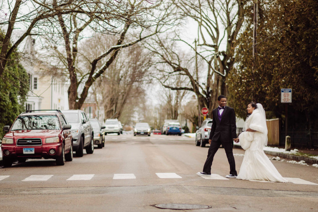A couple that decided to elope in Connecticut walks through a crosswalk in Stonington.