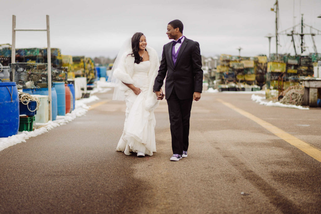 A bride and groom hold hands and walk in Stonington during their Connecticut elopement.