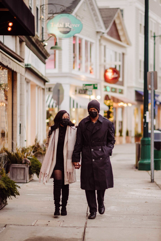 A couple walks down Main Street for their Mystic engagement photos.