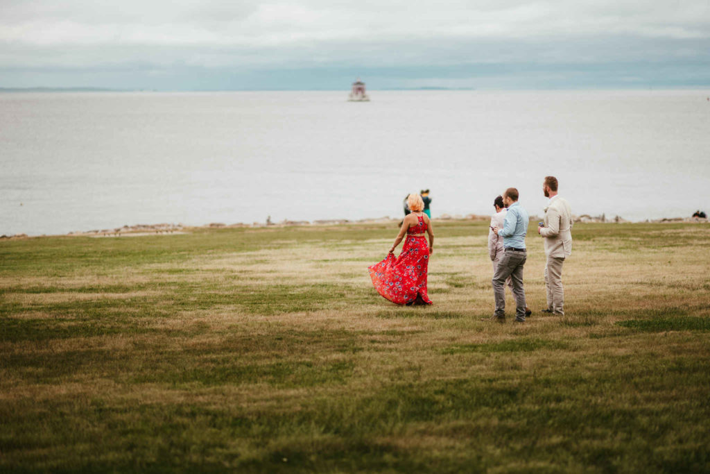 Guests enjoy the views of New London Ledge Lighthouse during the cocktail hour of an Avery Point wedding.
