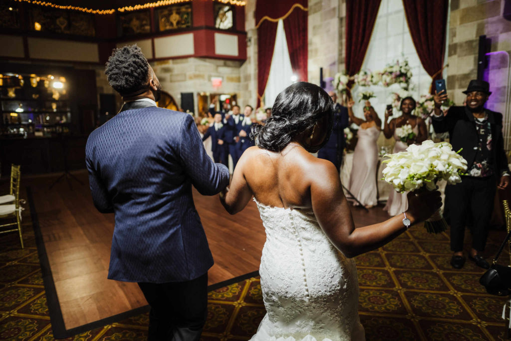 A bride and groom dance their way into their reception at CT wedding venue The Society Room of Hartford.