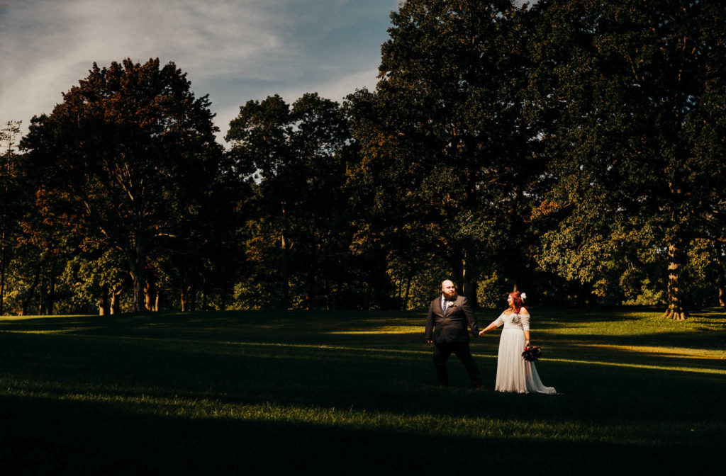 A bride and groom walk in a park, taken by Connecticut proposal photographer Terrence Irving.
