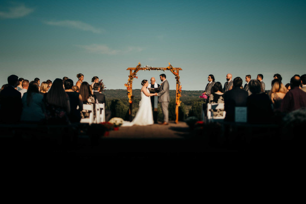 A bride, groom, and their wedding party take part in a ceremony at The Overlook, one of the great rustic wedding venues in Connecticut.