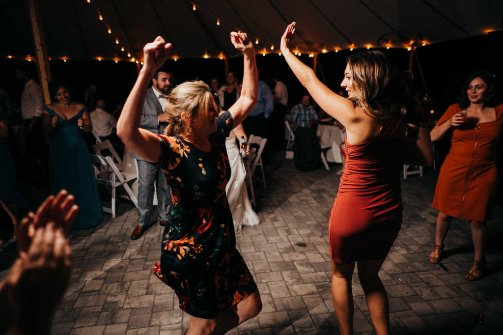 Wedding guests dance under the tent  at a rustic Connecticut wedding venue.