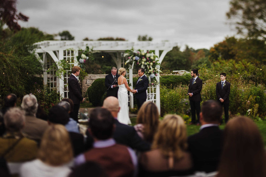 During their Stonington wedding, a bride and groom stand at the altar at Stone Acres Farm.