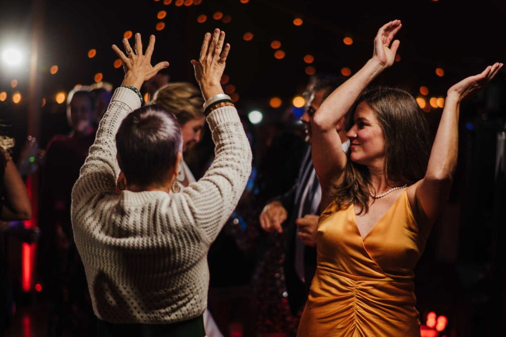 Guests of a wedding at Stone Acres Farm in Stonington dance under a tent.