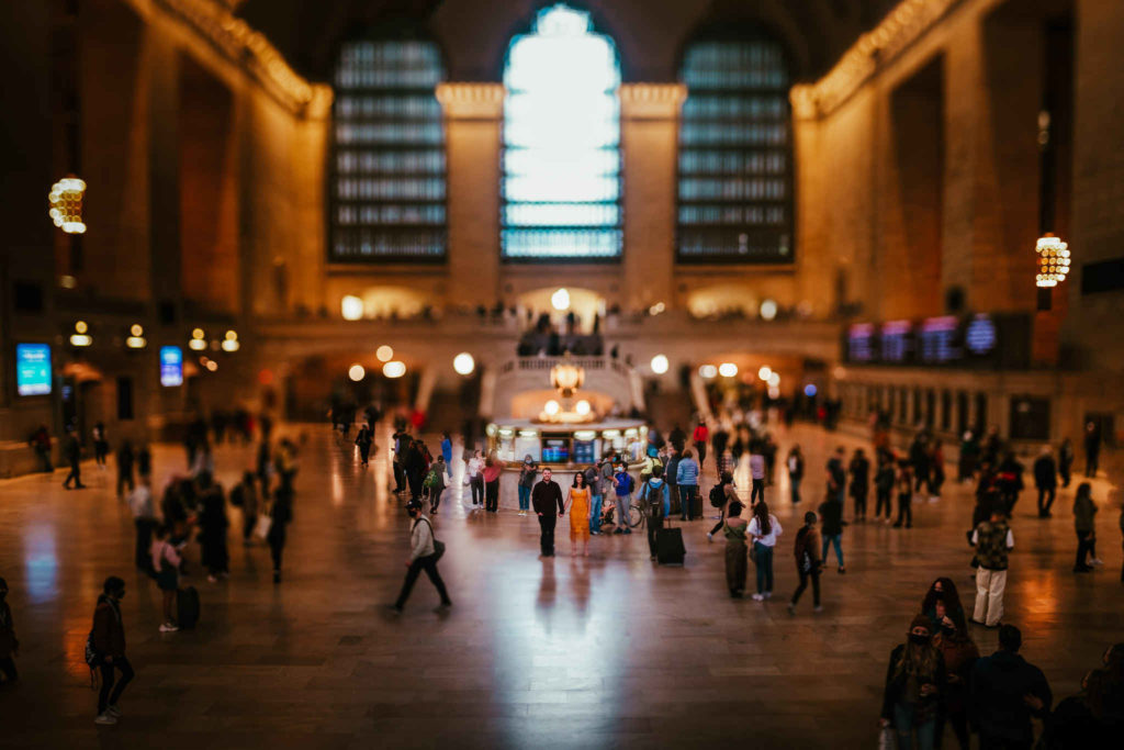 A couple poses amongst the crowd in Grand Central Station's main terminal during their New York City engagement session.