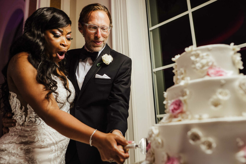 A bride and groom cut their cake during their Aria Wedding Banquet Facility wedding.