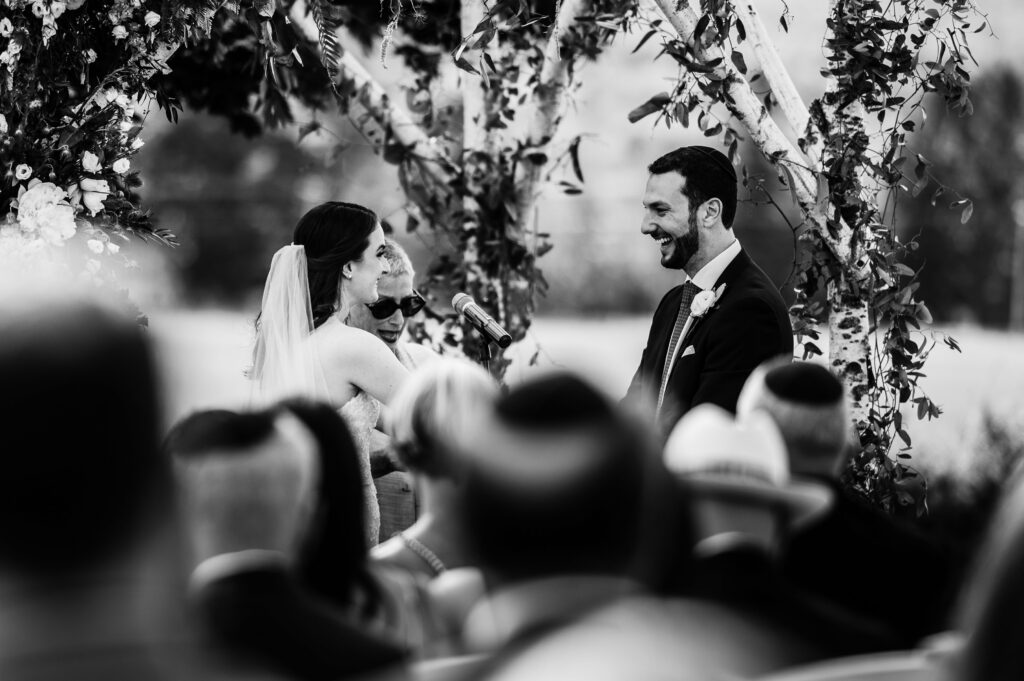The bride and groom smile at each other during their LionRock Farm wedding ceremony.