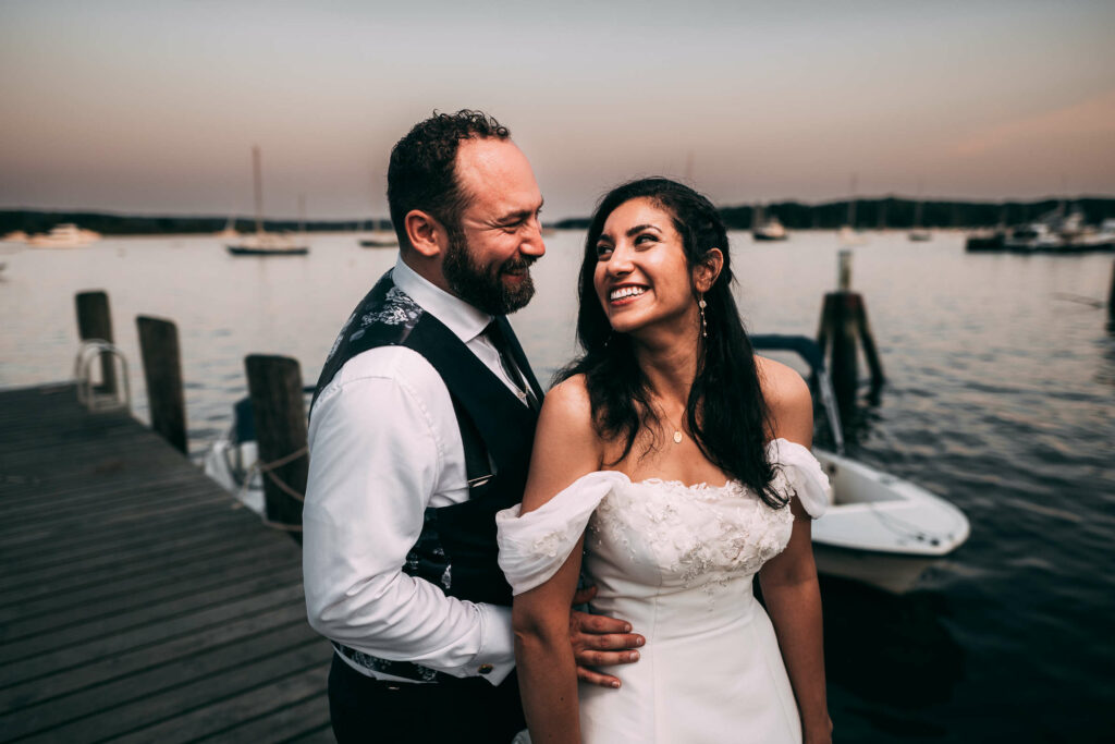 A bride and groom smile at each other in front of a river with Connecticut wedding photographer Terrence Irving.