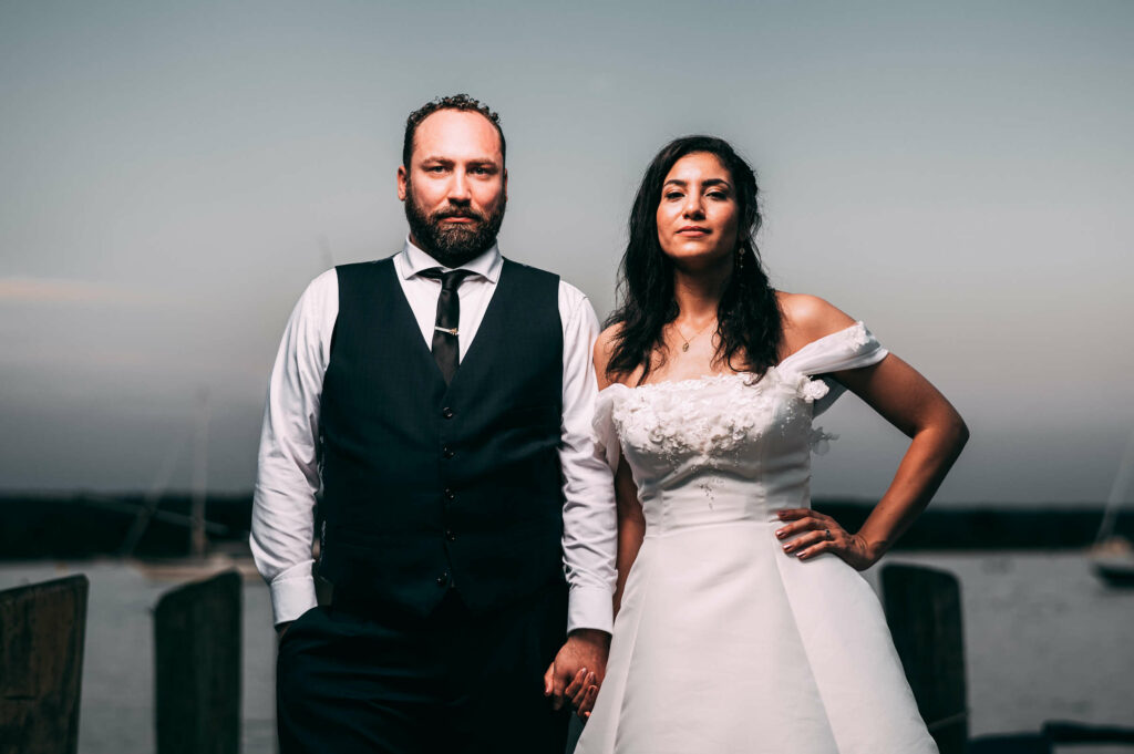 A bride and groom hold hands with serious looks at Connecticut River Museum, one of the best places to get married in CT.