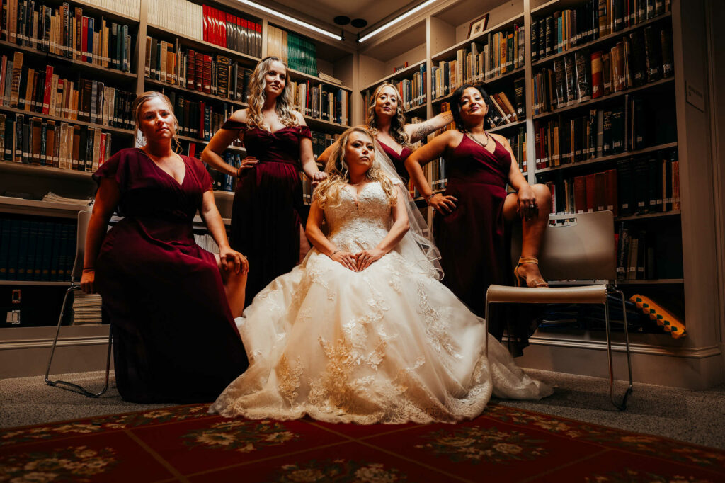 A bride poses with her bridesmaids in the basement of the Webb Deane Stevens Holcombe Education Center during her Webb Barn wedding.