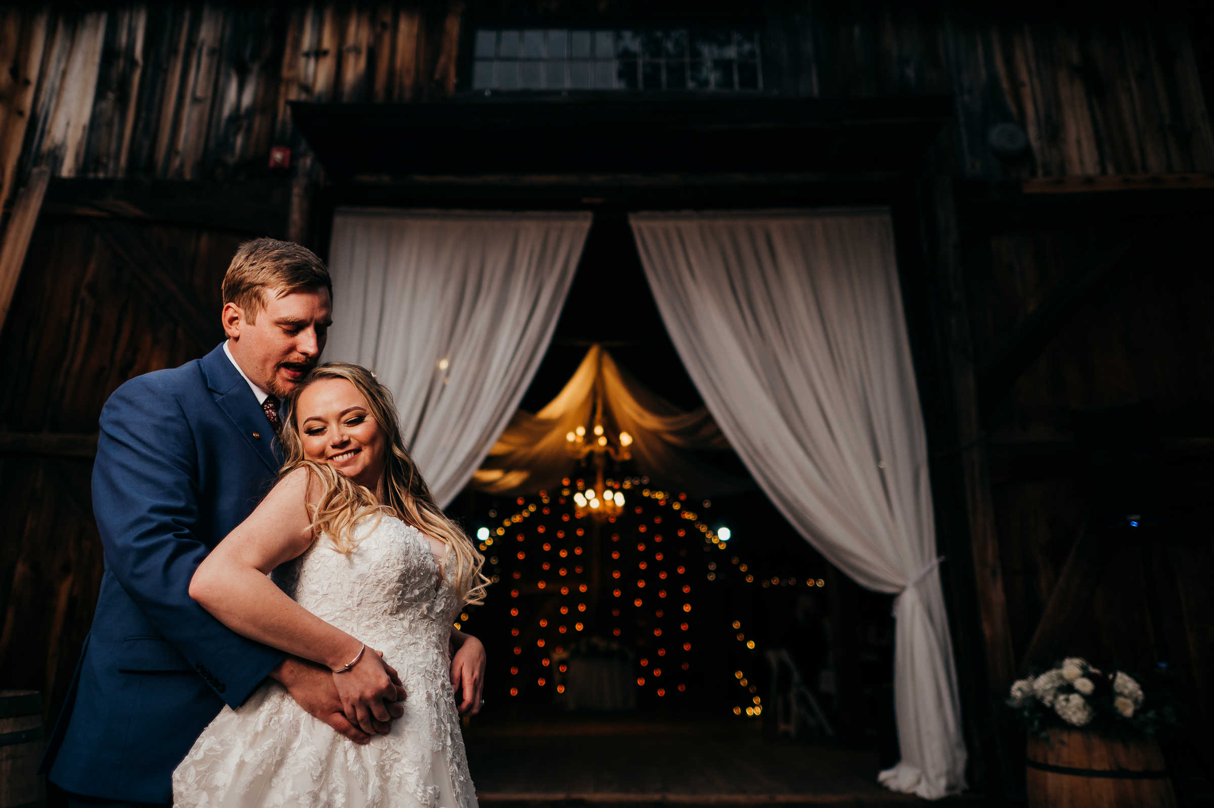 A bride and groom embrace together in front of the barn wedding venue in Connecticut.