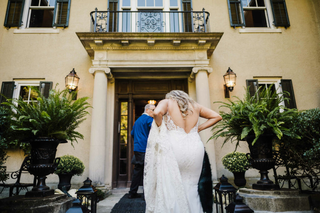 A bride walks through the front door of the mansion before her Lord Thompson Manor wedding.