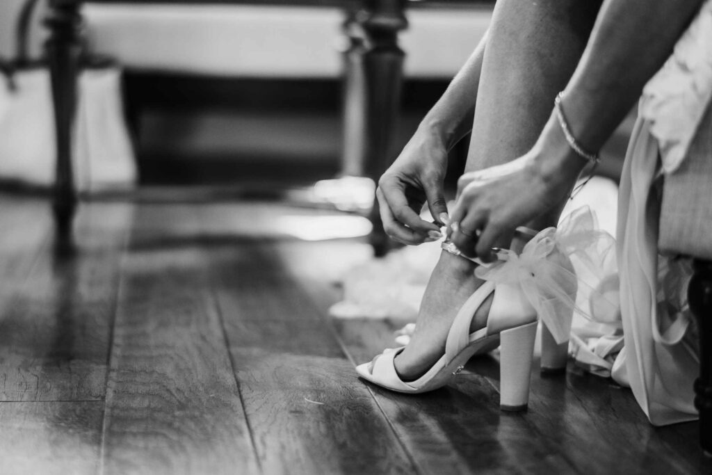 A bride puts on her shoes before her St. Clements Castle wedding.