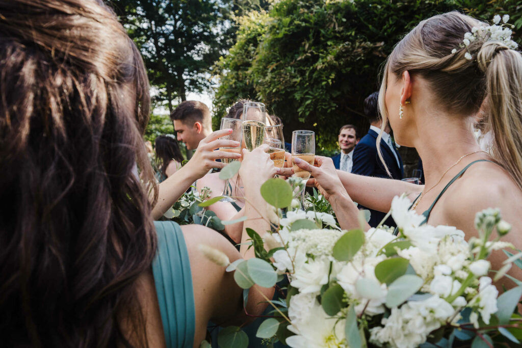 Bridesmaids cheers with glasses of champagnes during a a St. Clements Castle wedding.