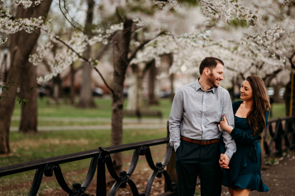 A couple walks together during their engagement session in Wooster Square Park in New Haven, CT.