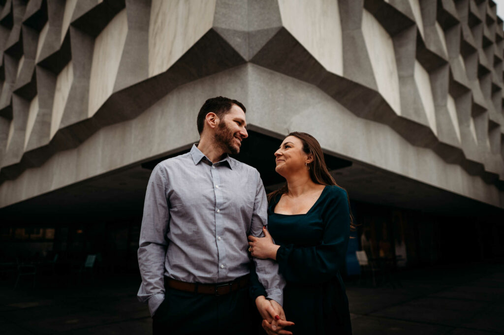 A couple poses in front of Beinecke Rare Book Library at Yale during their engagement session.
