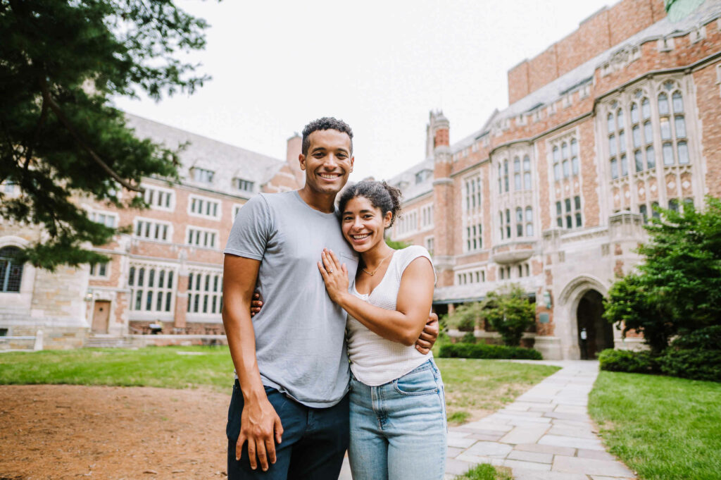 An engaged couple poses together in The Courtyard during their engagement session at Yale.