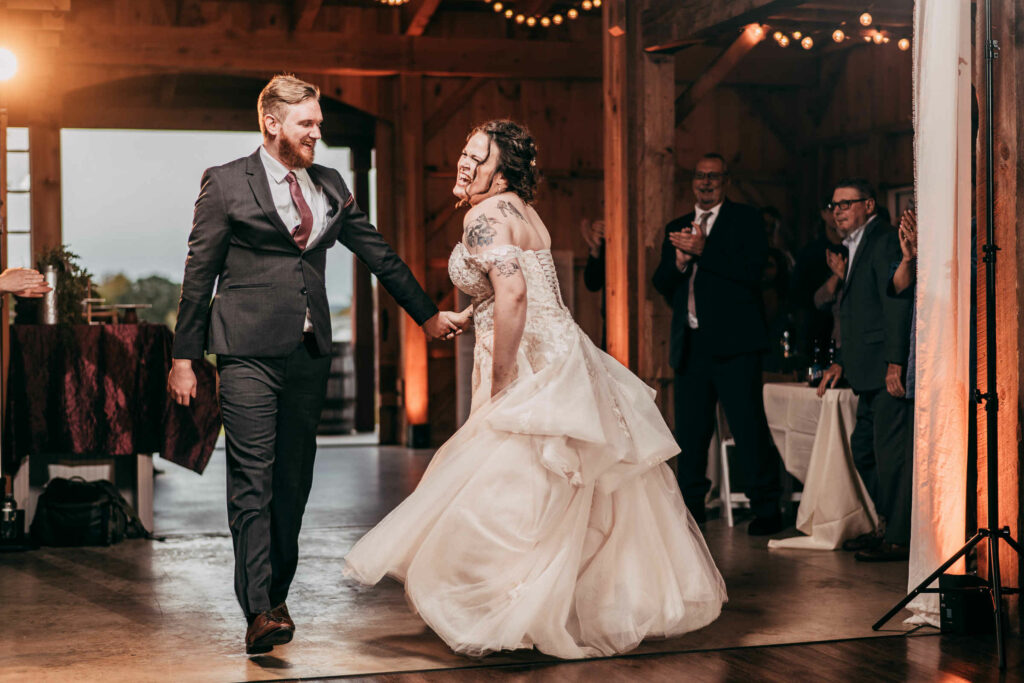A bride and groom make their entrance into their rustic wedding venue in Connecticut.