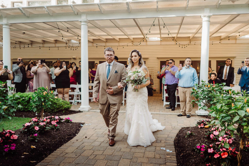 A bride is walked down the aisle by her father during her Cascade wedding.