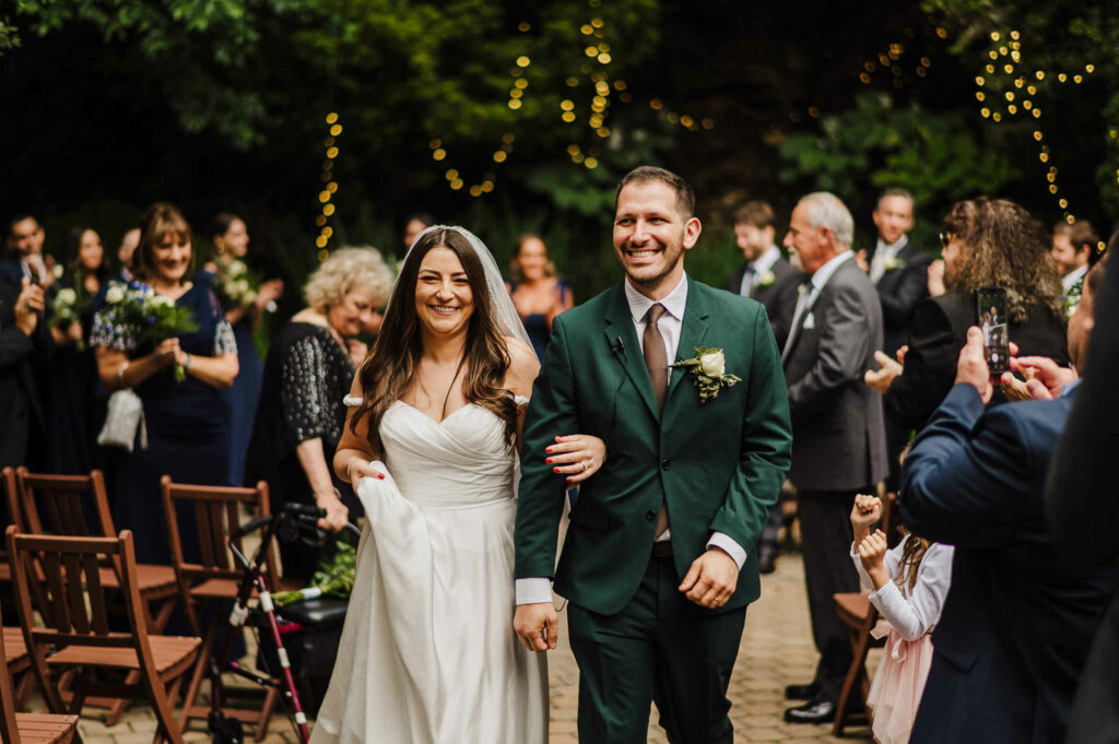 A couple walks down the aisle after their ceremony at WoodWinds, among the most affordable wedding venues in Connecticut.