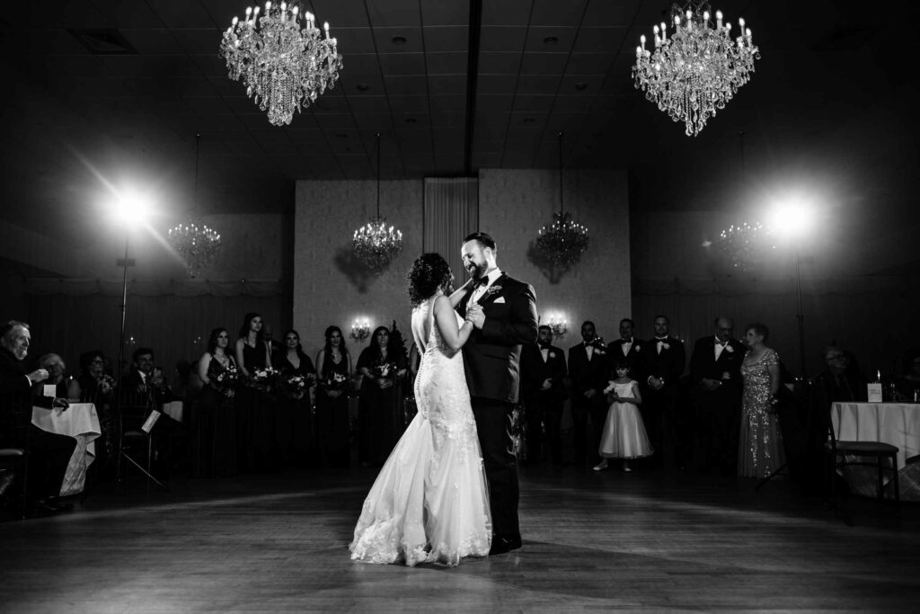 A black and white photo of a couple enjoying the first dance at their wedding at Cascade Hamden.