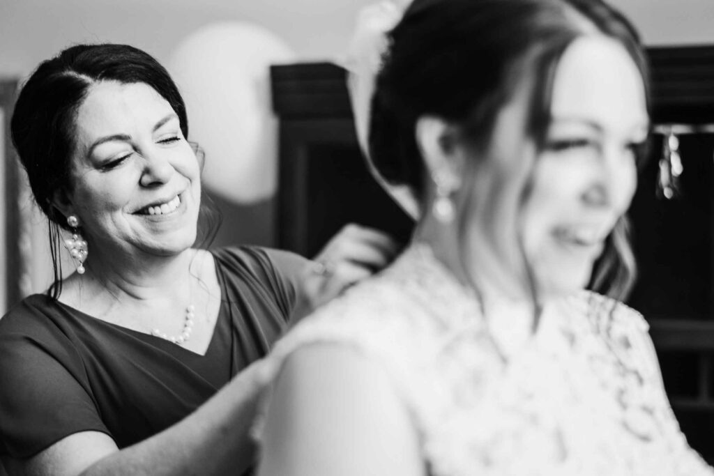A bride gets help from her mother while preparing for her Pond House Café wedding.