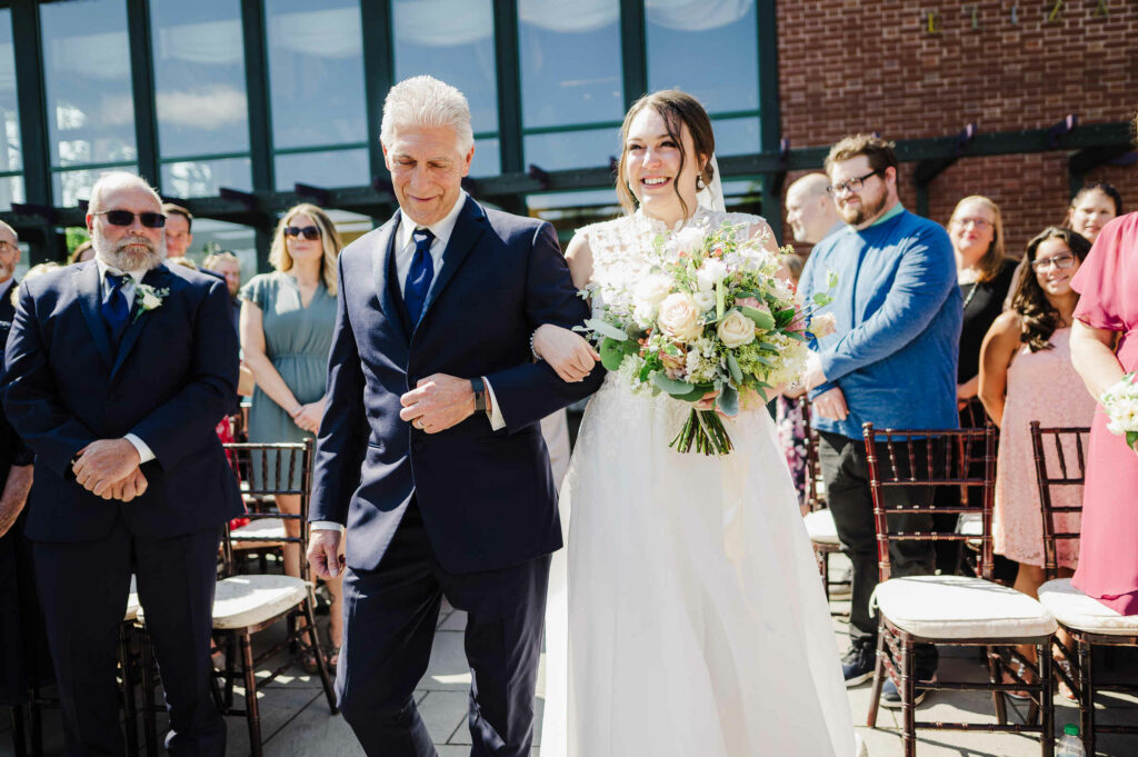 A father walks his bride daughter down the aisle during her Pond House Café wedding.