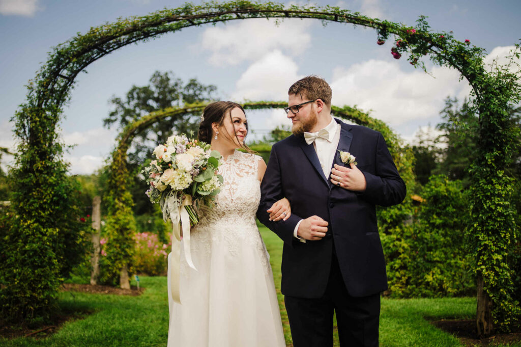 A bride and groom walk through the Rose Garden during their wedding at Elizabeth Park.
