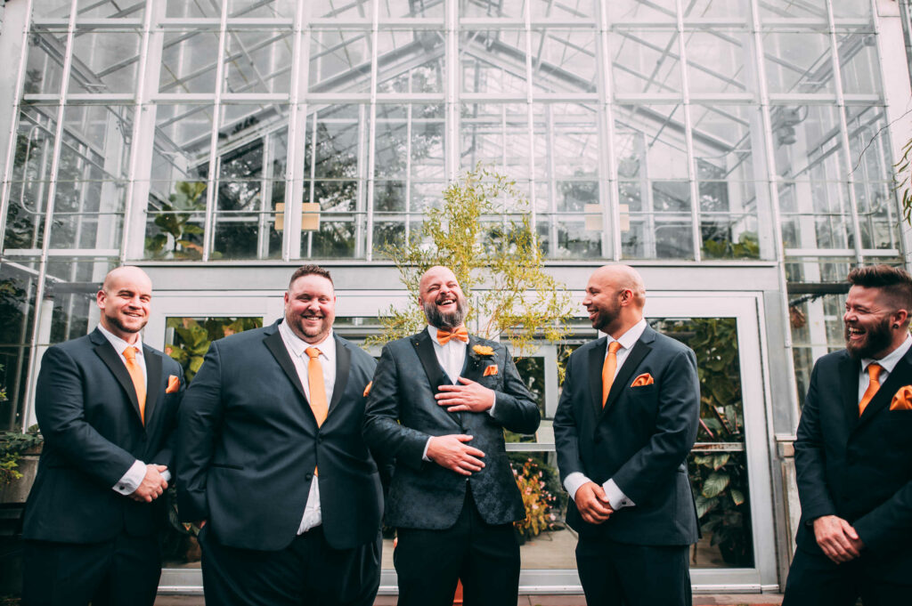 The groom laughs with his groomsmen before his Roger Williams Botanical Center wedding ceremony.