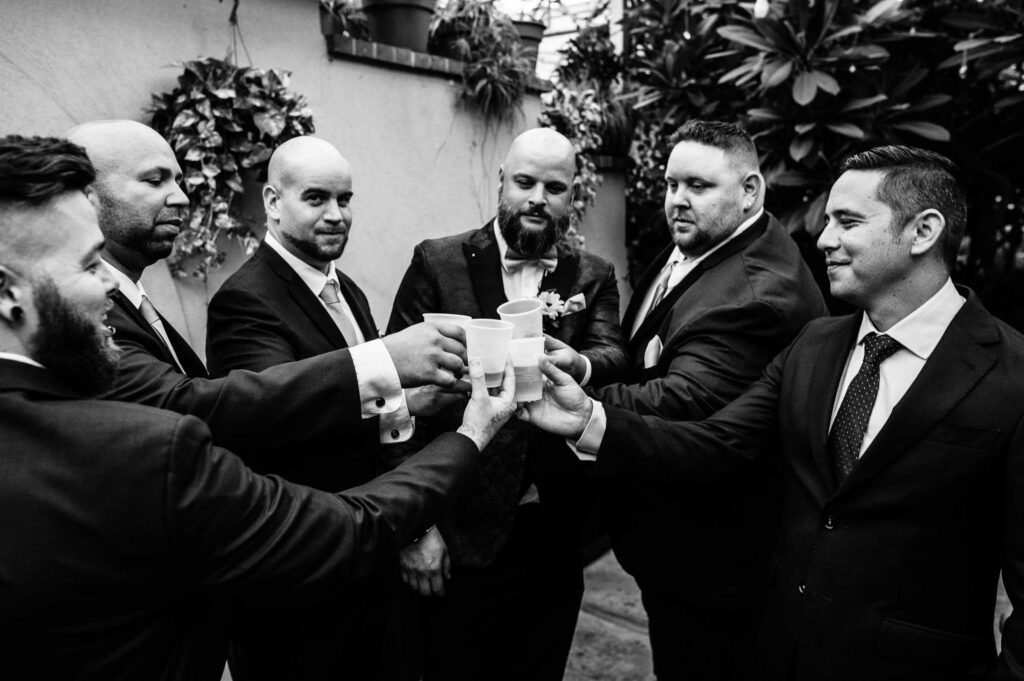 The groom and groomsmen toast together during his Roger Williams Botanical Center wedding.