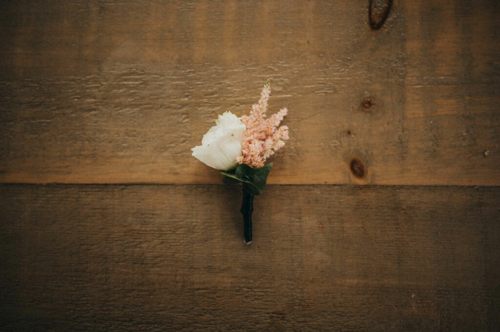A groom's boutonniere is pictured before his hops company wedding.