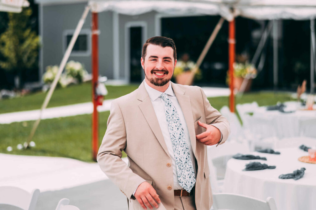 A groom walks under the tent at the Hops Company on the way to the first look before his THC Derby wedding.