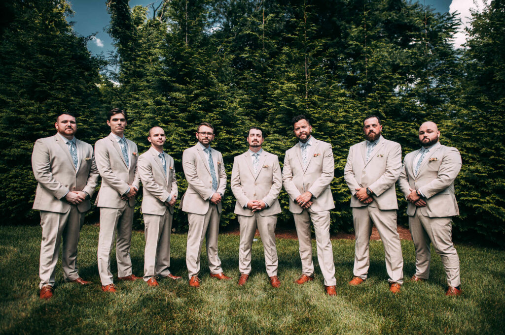 The groom and groomsmen pose together during his hops company wedding.