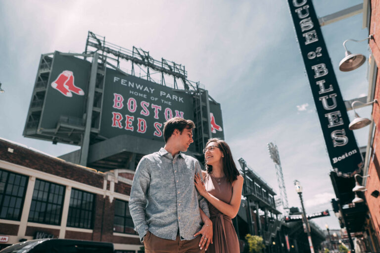 A couple poses together outside of Fenway Park during their Boston engagement session.