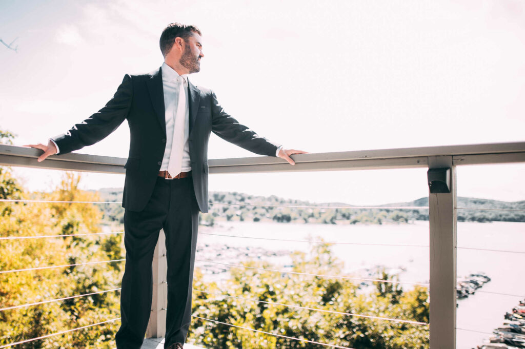 A groom poses on a balcony before his Candlewood Inn wedding.