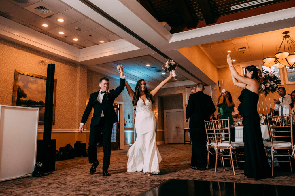 The bride and groom enter the reception ballroom during their Lake of Isles wedding at Foxwoods Casino.