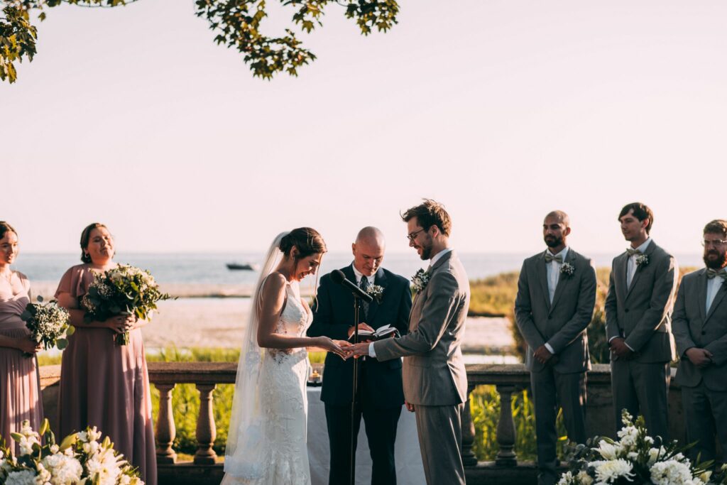 A couple exchanges rings during their ceremony at Eolia Mansion, a garden wedding venue in Connecticut.