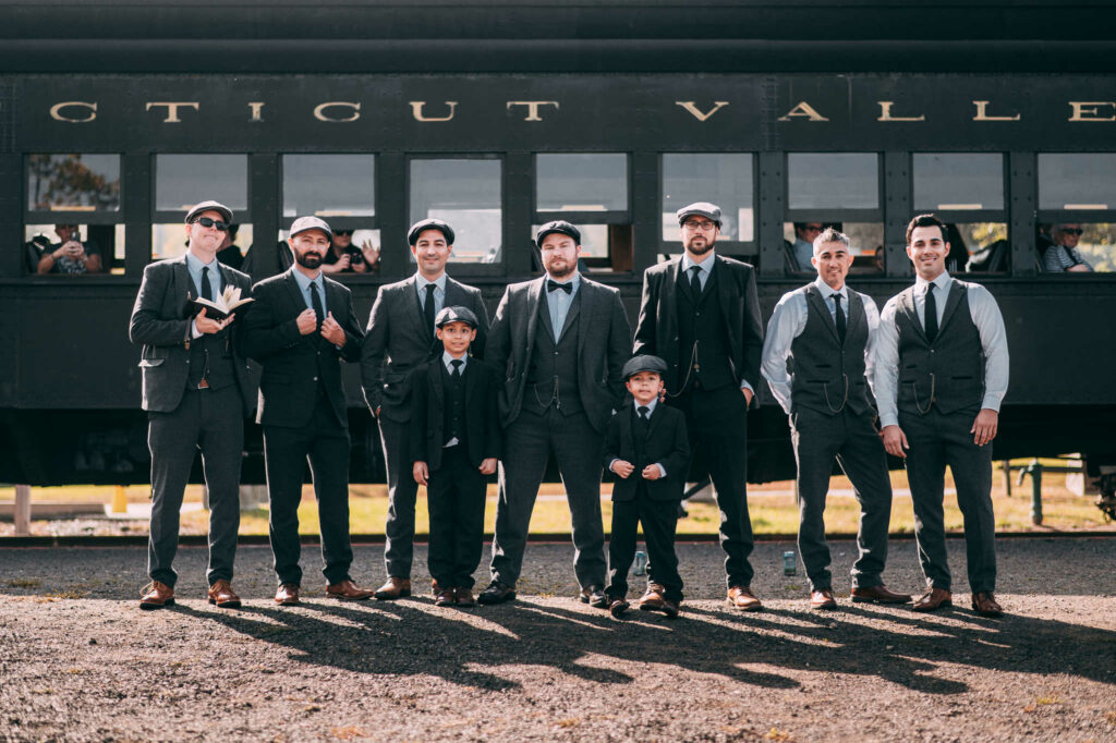 A groom and his groomsmen at an industrial wedding venue in Connecticut with a steam train.
